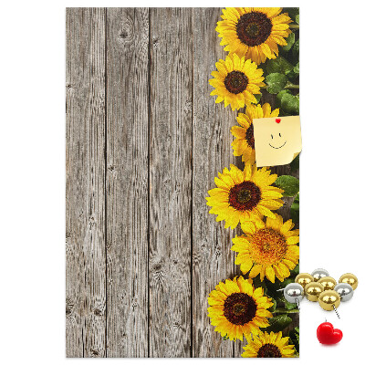 Memobord van kurk met zonnebloemen op een houten achtergrond
