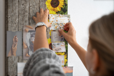 Memobord van kurk met zonnebloemen op een houten achtergrond