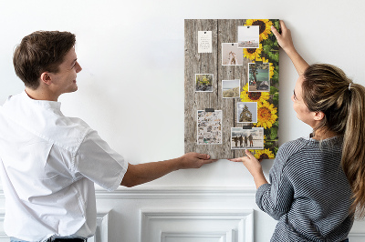 Memobord van kurk met zonnebloemen op een houten achtergrond