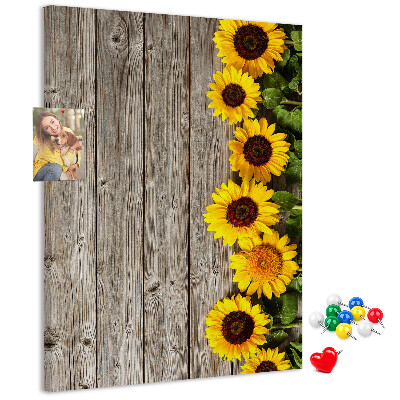 Memobord van kurk met zonnebloemen op een houten achtergrond