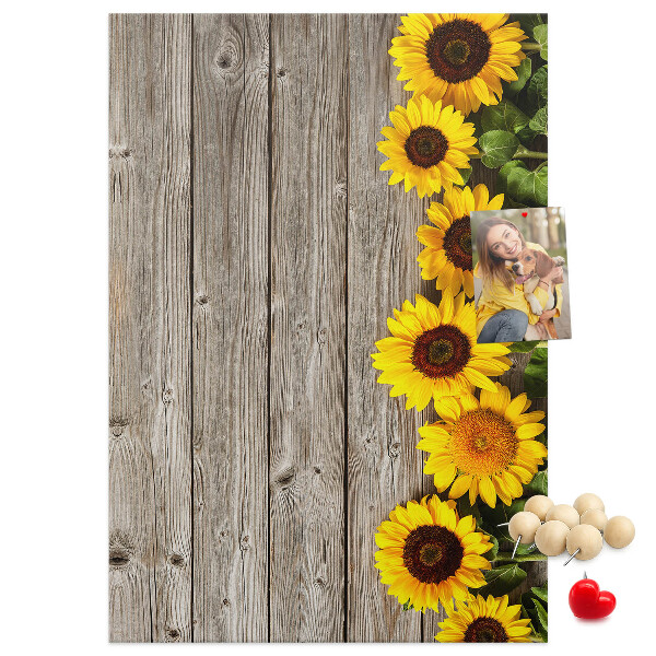 Memobord van kurk met zonnebloemen op een houten achtergrond