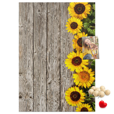 Memobord van kurk met zonnebloemen op een houten achtergrond