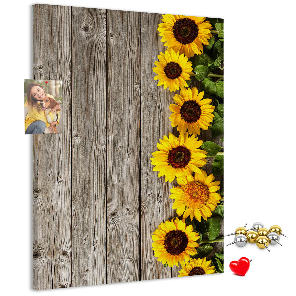 Memobord van kurk met zonnebloemen op een houten achtergrond