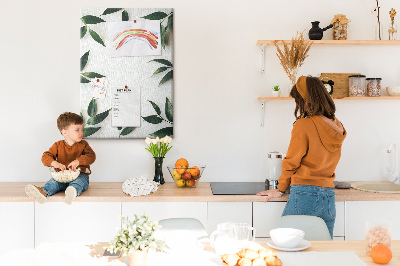 Memobord van kurk met groene bladeren op een lichte achtergrond