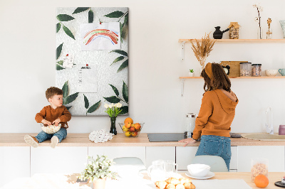 Memobord van kurk met groene bladeren op een lichte achtergrond