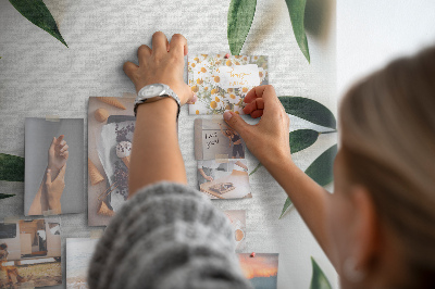 Memobord van kurk met groene bladeren op een lichte achtergrond
