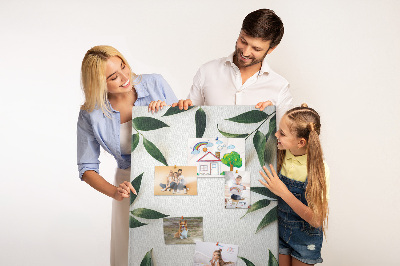Memobord van kurk met groene bladeren op een lichte achtergrond