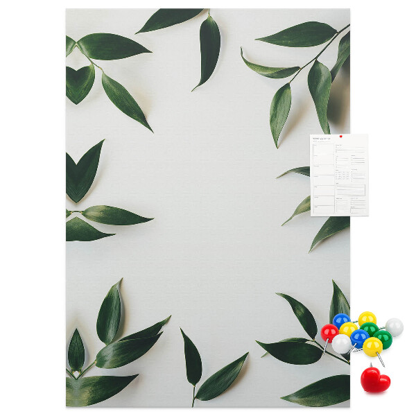 Memobord van kurk met groene bladeren op een lichte achtergrond