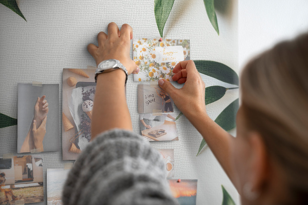 Memobord van kurk met groene bladeren op een lichte achtergrond
