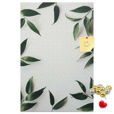 Memobord van kurk met groene bladeren op een lichte achtergrond