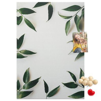 Memobord van kurk met groene bladeren op een lichte achtergrond