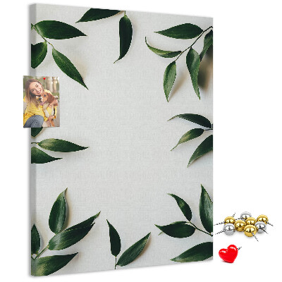 Memobord van kurk met groene bladeren op een lichte achtergrond
