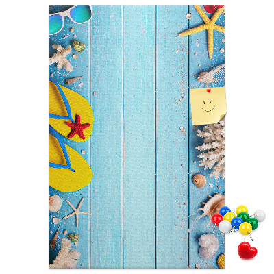 Memobord van kurk met zomerse strandaccessoires op een blauwe achtergrond