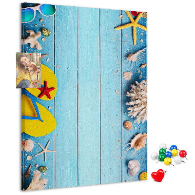 Memobord van kurk met zomerse strandaccessoires op een blauwe achtergrond