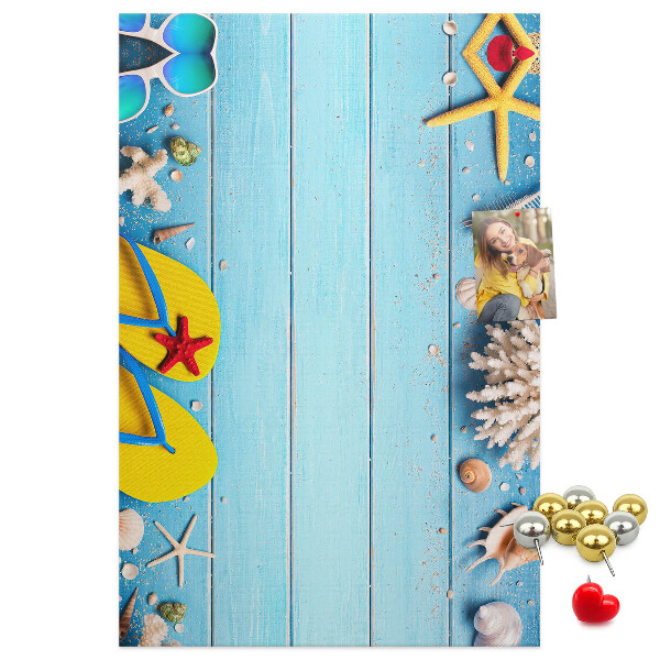 Memobord van kurk met zomerse strandaccessoires op een blauwe achtergrond