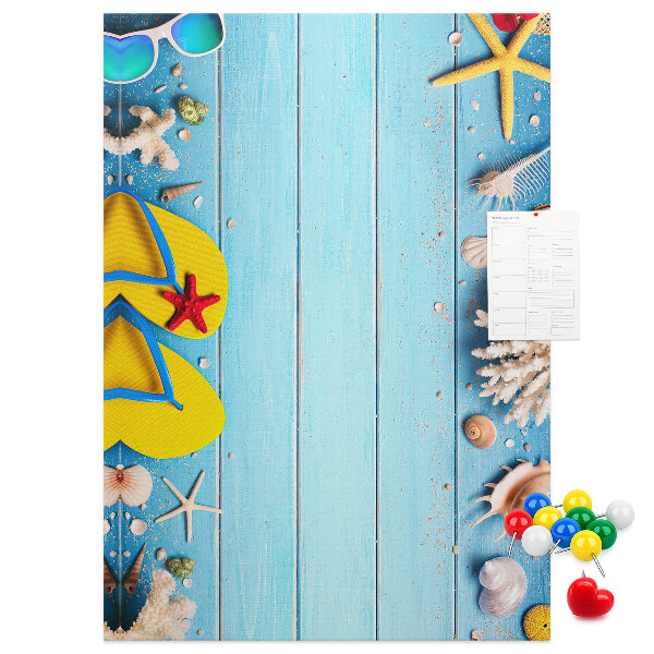 Memobord van kurk met zomerse strandaccessoires op een blauwe achtergrond