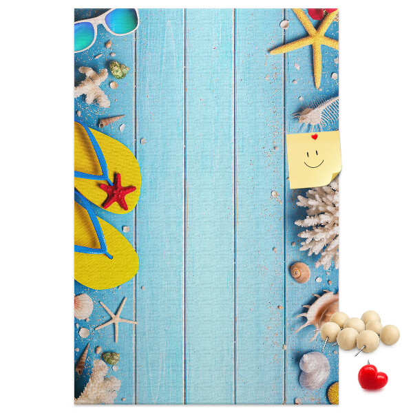 Memobord van kurk met zomerse strandaccessoires op een blauwe achtergrond