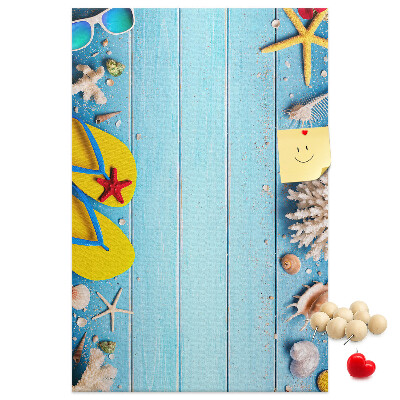 Memobord van kurk met zomerse strandaccessoires op een blauwe achtergrond