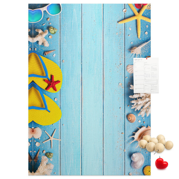 Memobord van kurk met zomerse strandaccessoires op een blauwe achtergrond