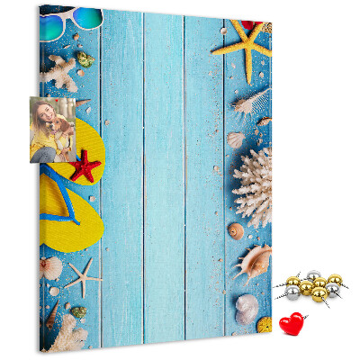 Memobord van kurk met zomerse strandaccessoires op een blauwe achtergrond