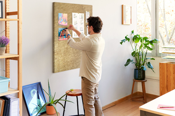 Kurk memobord met goudkleurig papier en gekleurde spelden