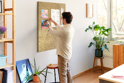 Kurk memobord met goudkleurig papier en gekleurde spelden