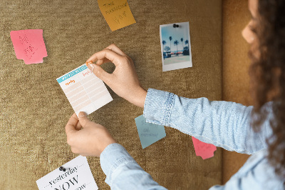 Kurk memobord met goudkleurig papier en gekleurde spelden