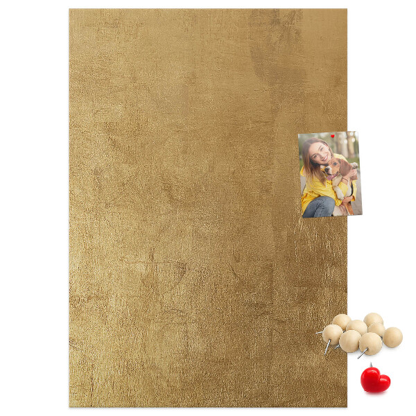 Kurk memobord met goudkleurig papier en gekleurde spelden