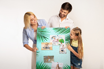 Memobord van kurk met palmbladeren op een blauwe achtergrond