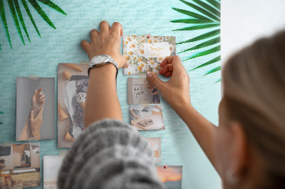 Memobord van kurk met palmbladeren op een blauwe achtergrond