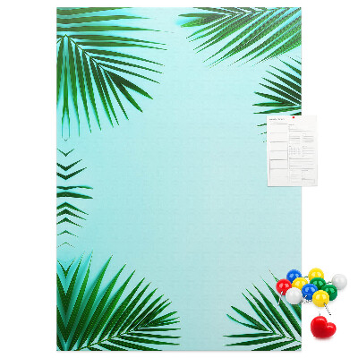 Memobord van kurk met palmbladeren op een blauwe achtergrond