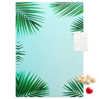 Memobord van kurk met palmbladeren op een blauwe achtergrond