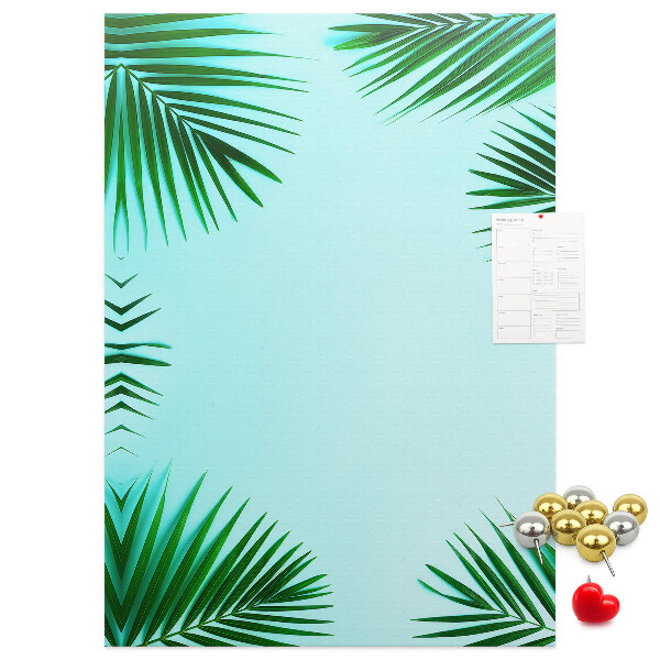 Memobord van kurk met palmbladeren op een blauwe achtergrond
