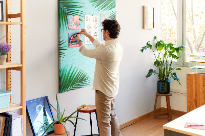 Memobord van kurk met palmbladeren op een blauwe achtergrond