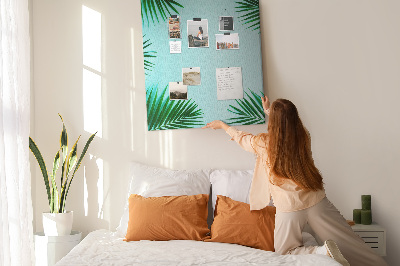 Memobord van kurk met palmbladeren op een blauwe achtergrond