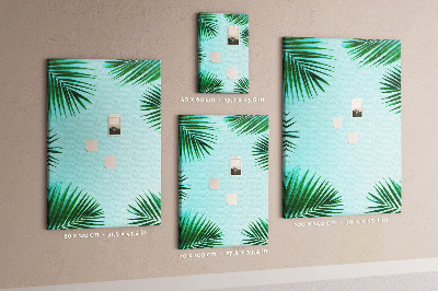 Memobord van kurk met palmbladeren op een blauwe achtergrond