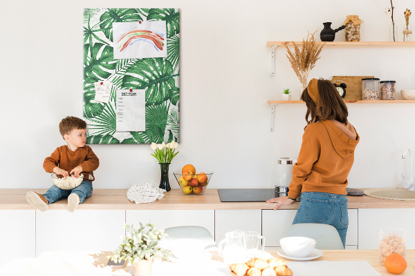 Prikbord van kurk met een print van Monstera-bladeren op een lichte achtergrond