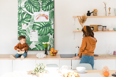 Prikbord van kurk met een print van Monstera-bladeren op een lichte achtergrond