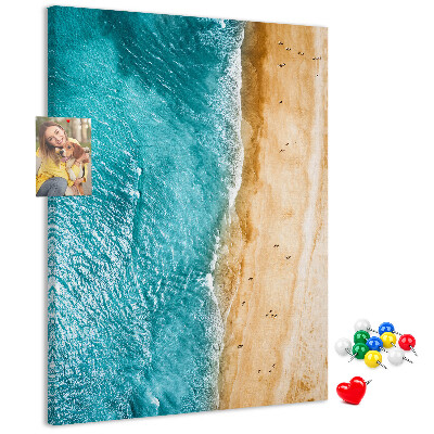 Kurken memobord met een afbeelding van een strand met golvende zee en mensen