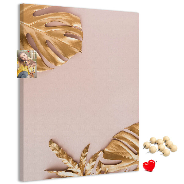 Memobord van kurk met gouden blaadjes op een zachtroze achtergrond