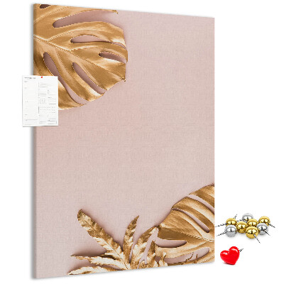 Memobord van kurk met gouden blaadjes op een zachtroze achtergrond