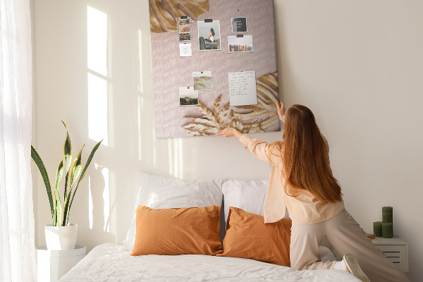 Memobord van kurk met gouden blaadjes op een zachtroze achtergrond