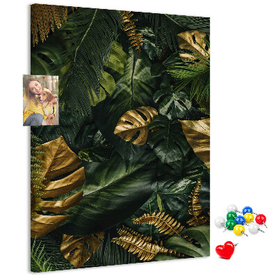 Memobord van kurk met gouden bladeren in een tropische plantencompositie