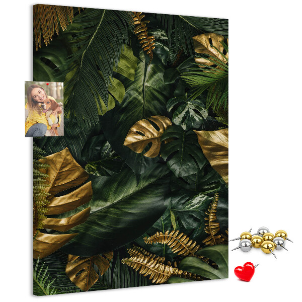 Memobord van kurk met gouden bladeren in een tropische plantencompositie