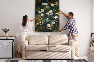 Memobord van kurk met gouden bladeren in een tropische plantencompositie