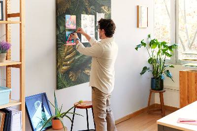 Memobord van kurk met gouden bladeren in een tropische plantencompositie