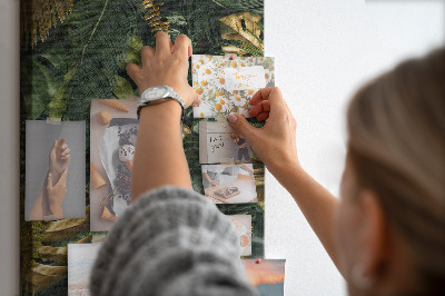 Memobord van kurk met gouden bladeren in een tropische plantencompositie