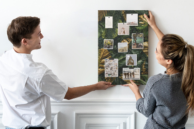 Memobord van kurk met gouden bladeren in een tropische plantencompositie