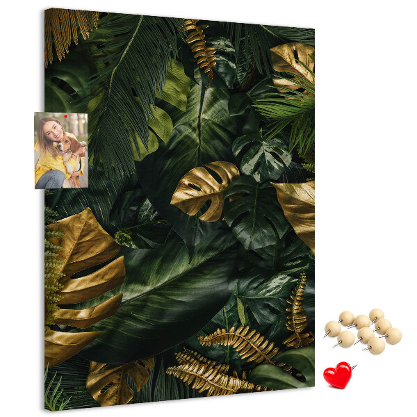 Memobord van kurk met gouden bladeren in een tropische plantencompositie