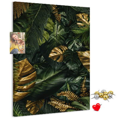 Memobord van kurk met gouden bladeren in een tropische plantencompositie